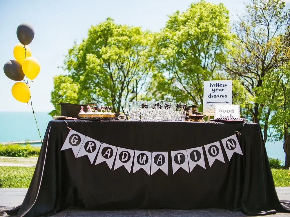 A graduation party setup with balloons, drinks, and cupcakes on a table